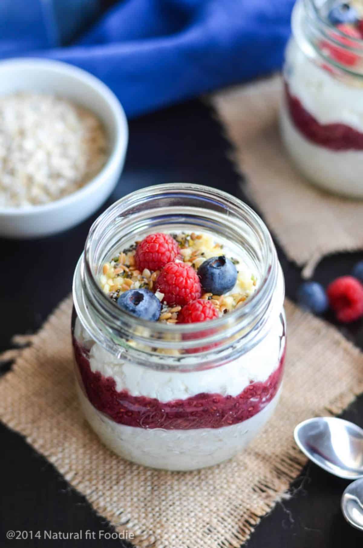 Blueberry Cottage Cheese Overnight Oats with fruits and nuts in a glass jar.