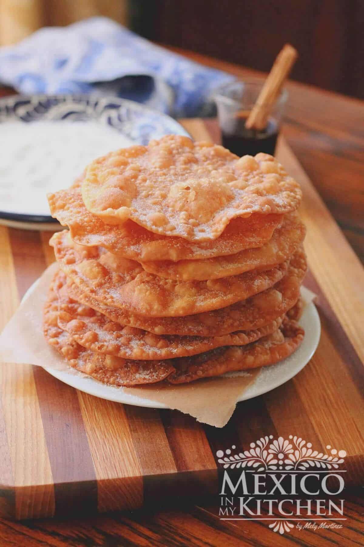 A pile of a Buñuelos mexican dessert on a white plate.