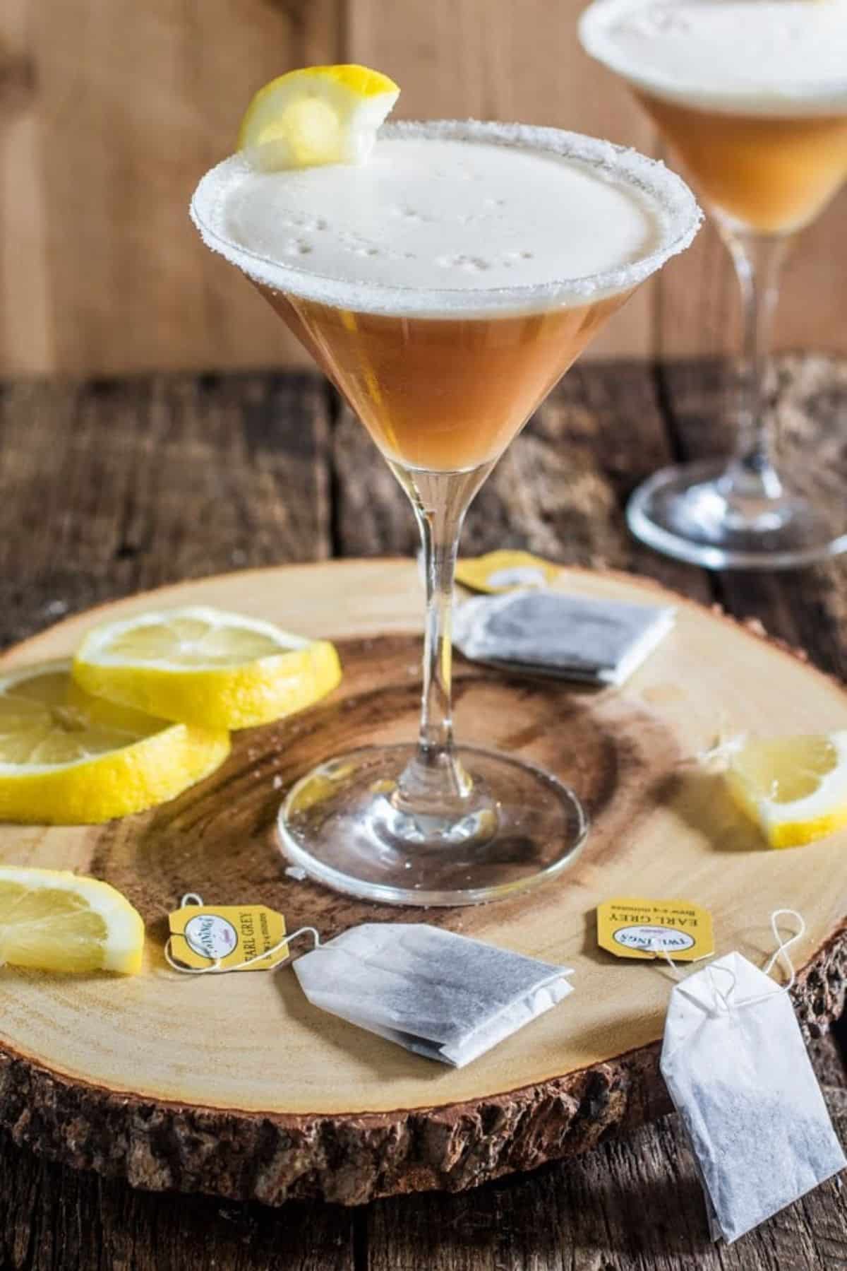 Earl Grey Martini in a tall glass cup on a wooden board.
