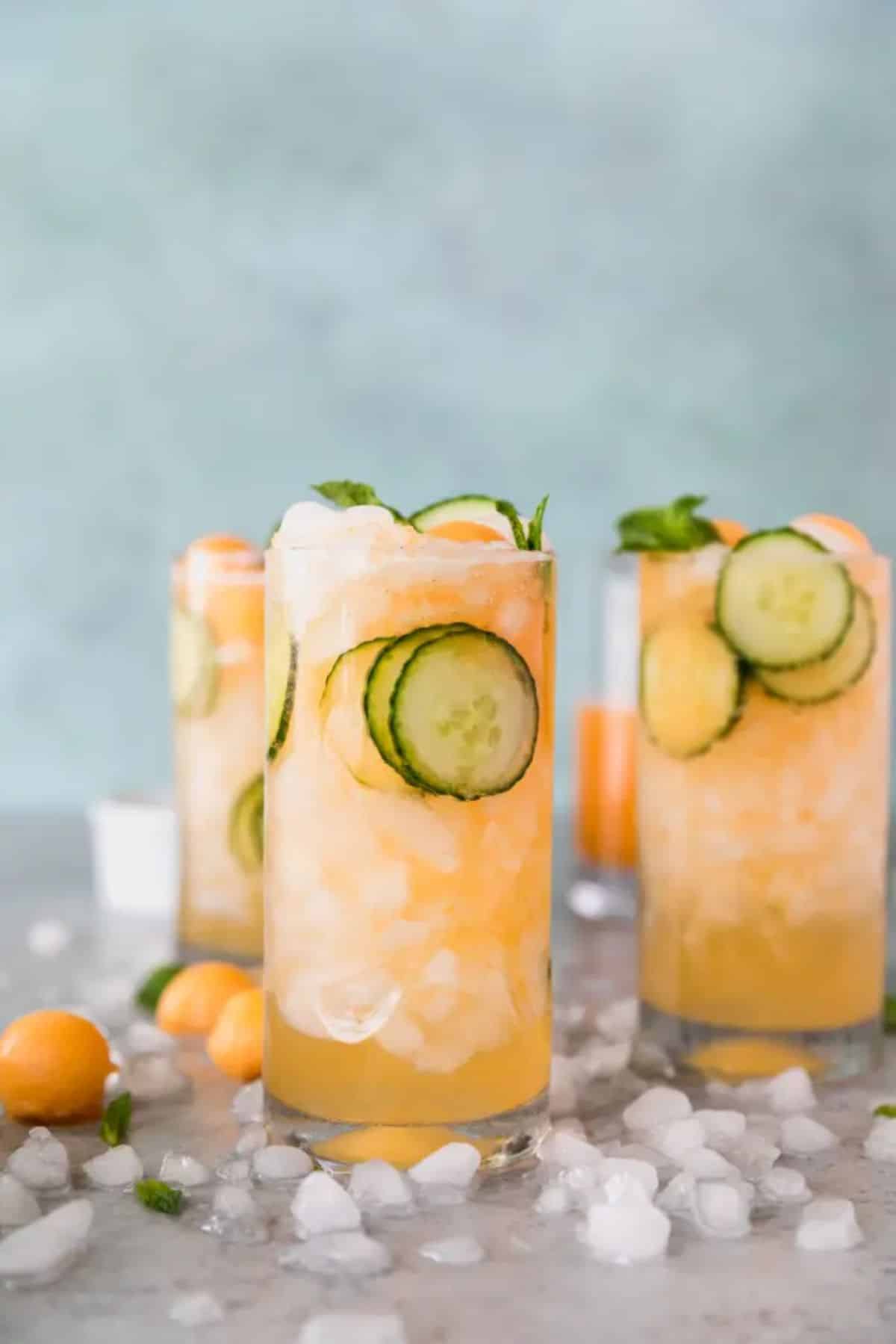 Cucumber Melon Gin Spritzer in tall glass cups with slices of cucumber.