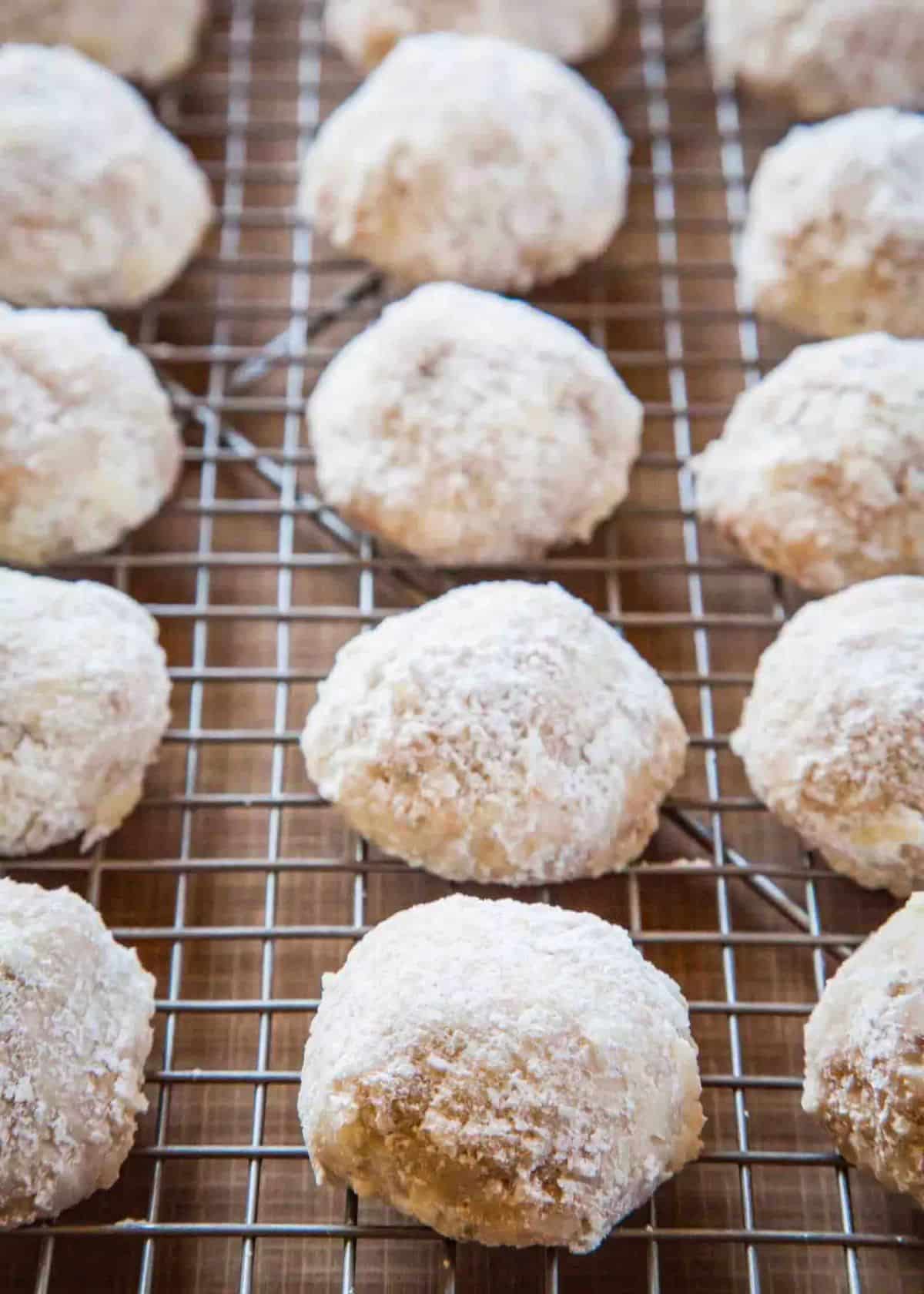 Mexican Wedding Cookies sprinkled by sugar on a baking grid.