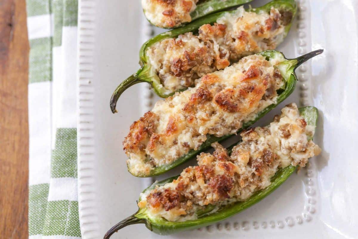 A bunch of Stuffed Jalapenos on a white tray.