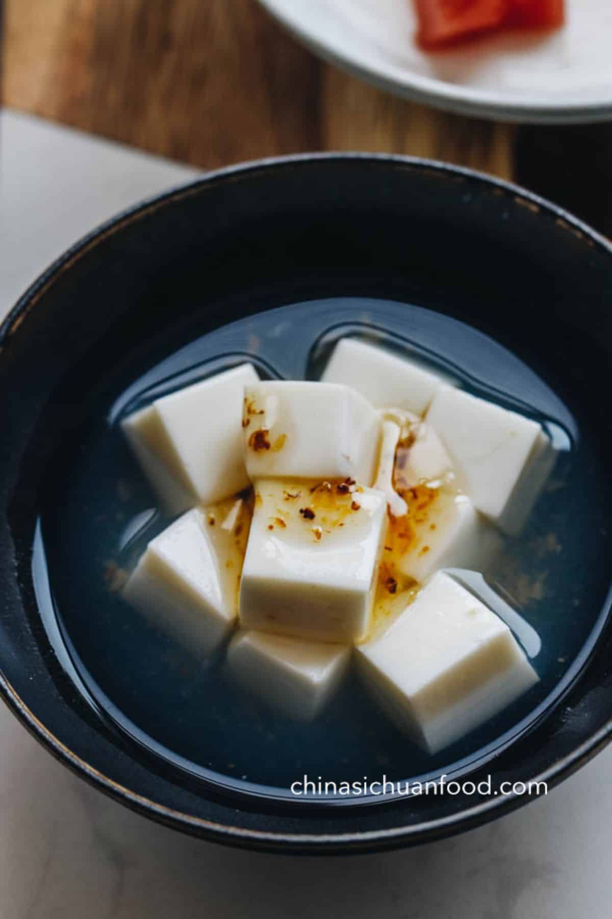 Almond Jelly chinese dessert in a black bowl.