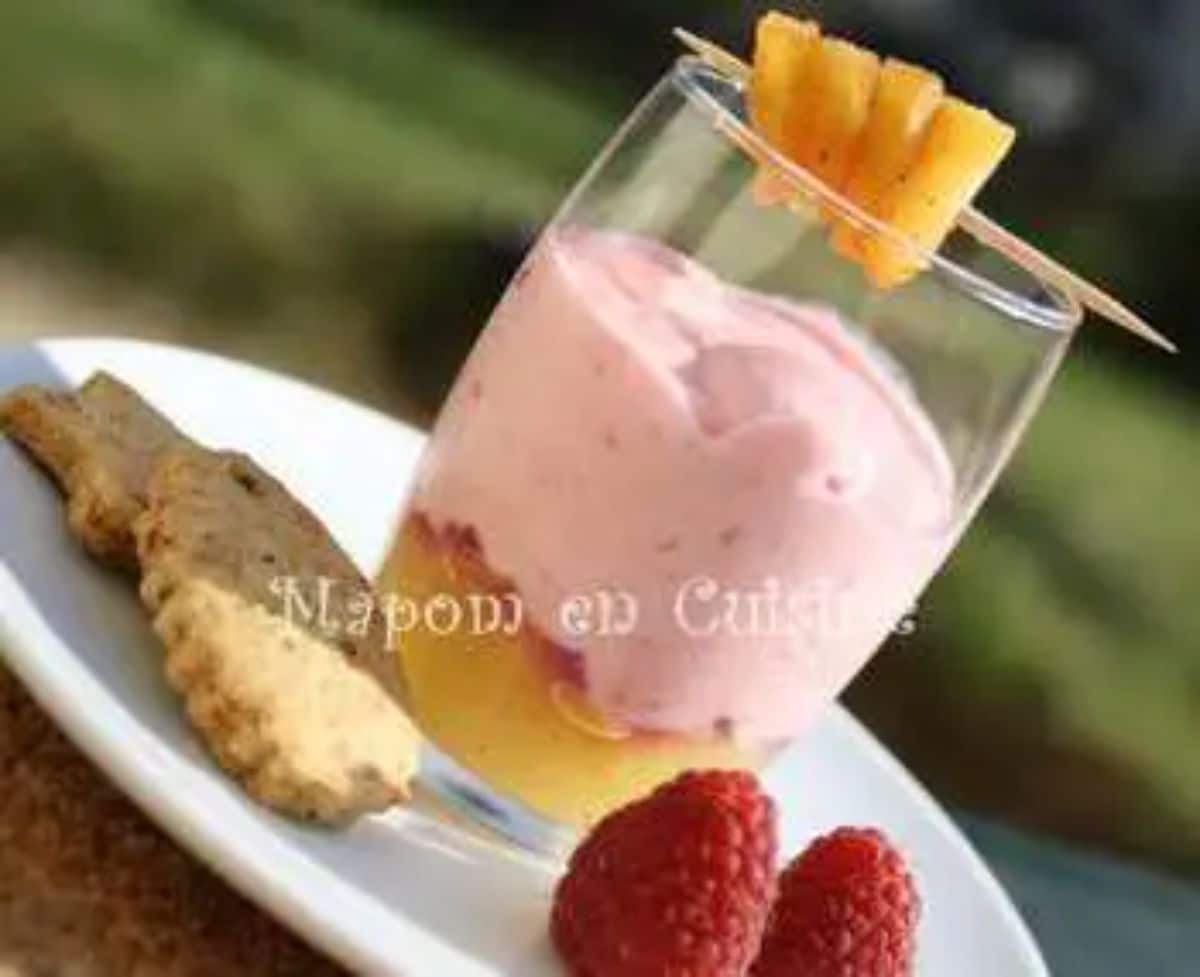 Mascarpone Raspberry Mousse in a glass cup with raspberries on a white plate.
