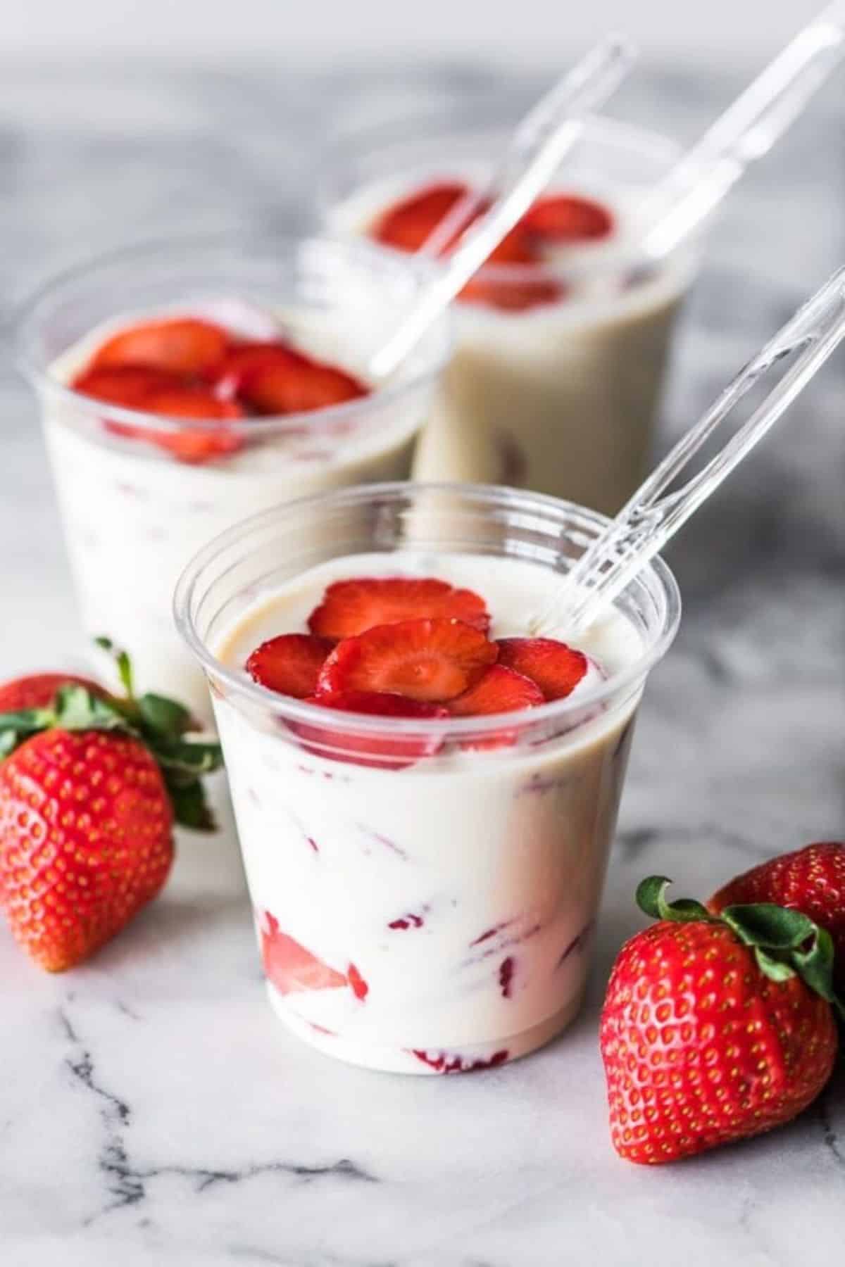 Fresas Con Crema mexican dessert in plastuc cups with spoons.