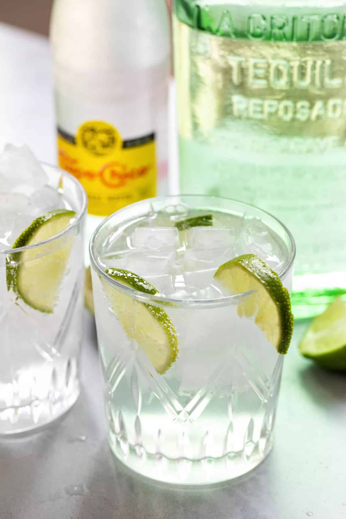 Ranch Water cocktail with ice, slices of lime in a glass cup.