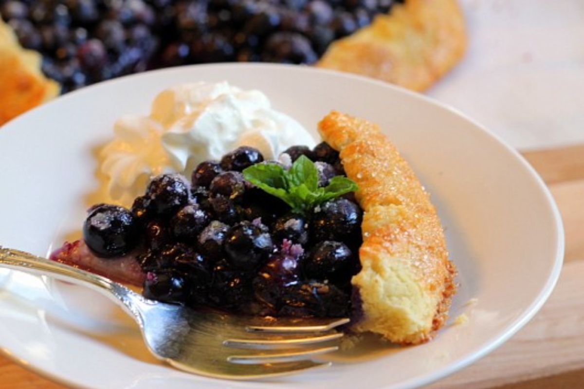 French Blueberry Galette on a white plate with a fork.