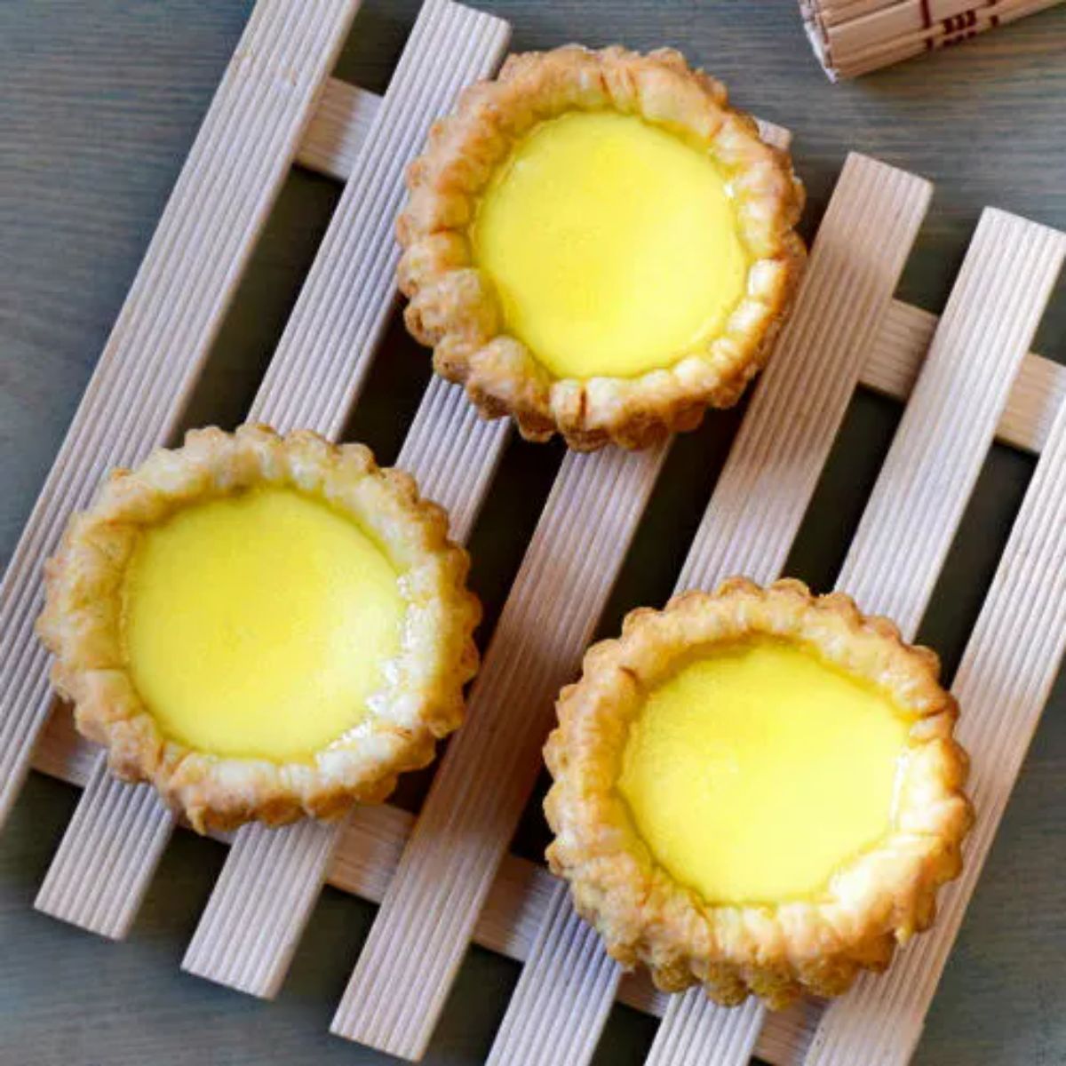Egg Tarts on a wooden tray.