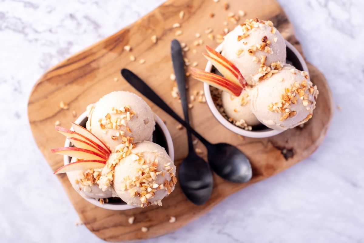 Dairy-Free Apple Strudel Ice Cream in two small bowls on a wooden board with two black spoons.