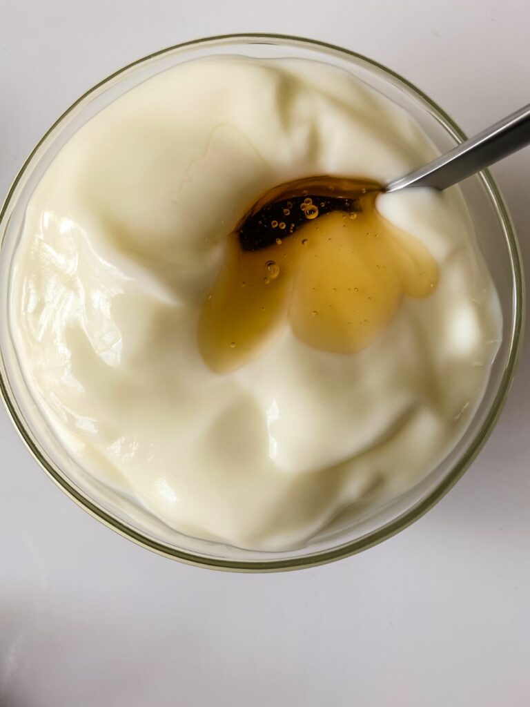 honey being stirred into bowl of yogurt