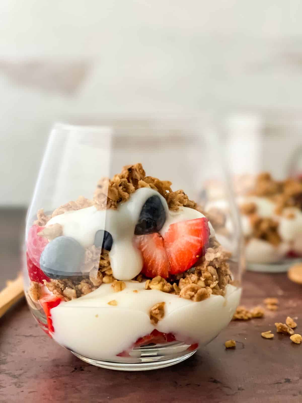 short glass of yogurt with fruit and granola